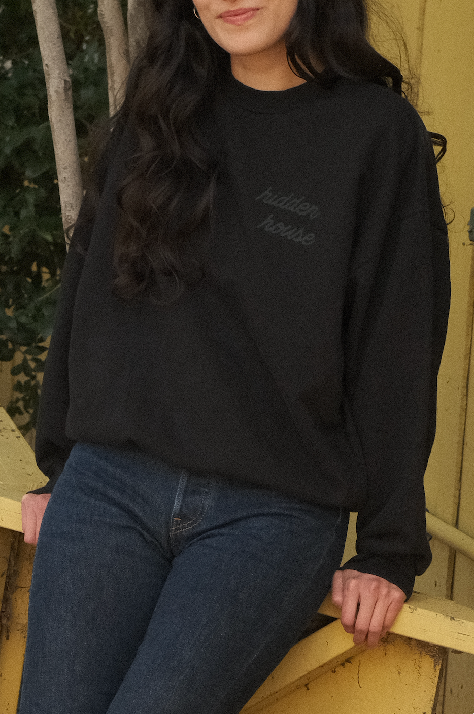Image of model wearing front of black sweatshirt.