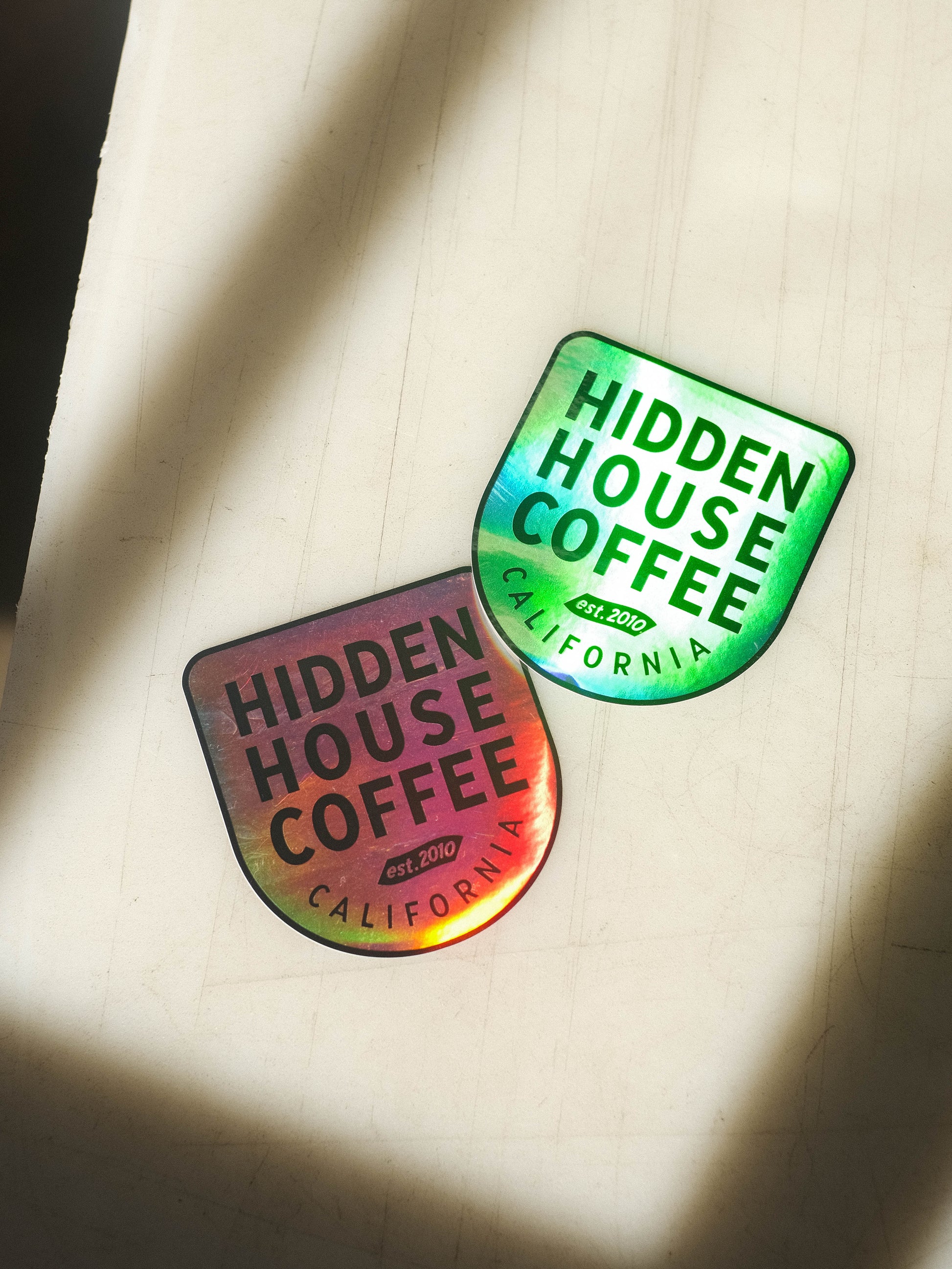 Image of holographic Hidden House logo sticker, showing reflection in the material.